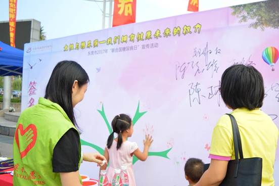 说明: 图2 志愿者指引居民签名留念