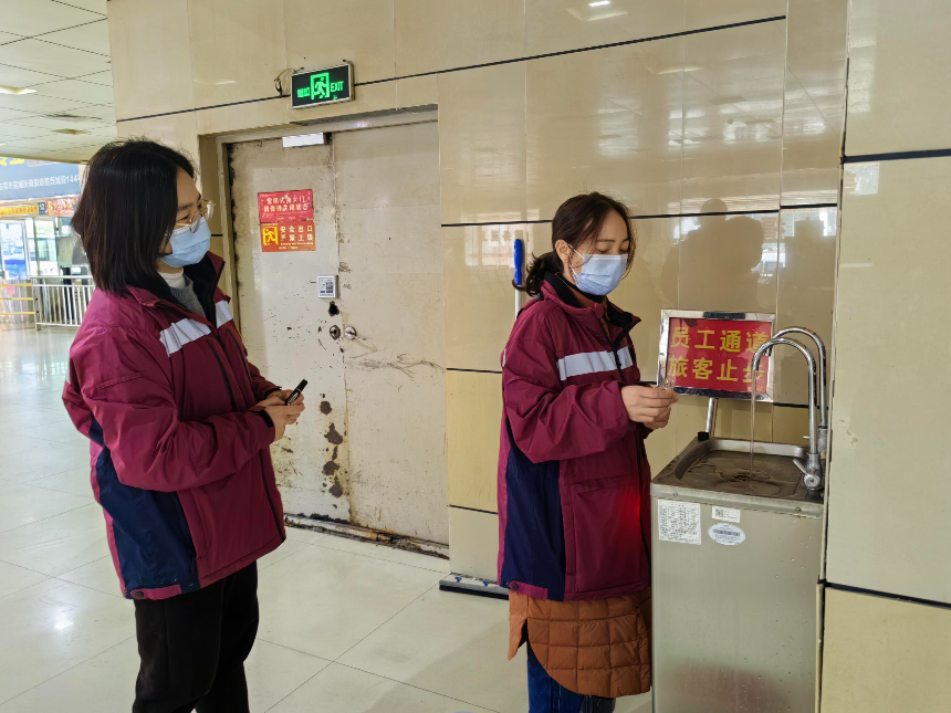 技术人员在车站候车大厅饮水处采集直饮水.jpg